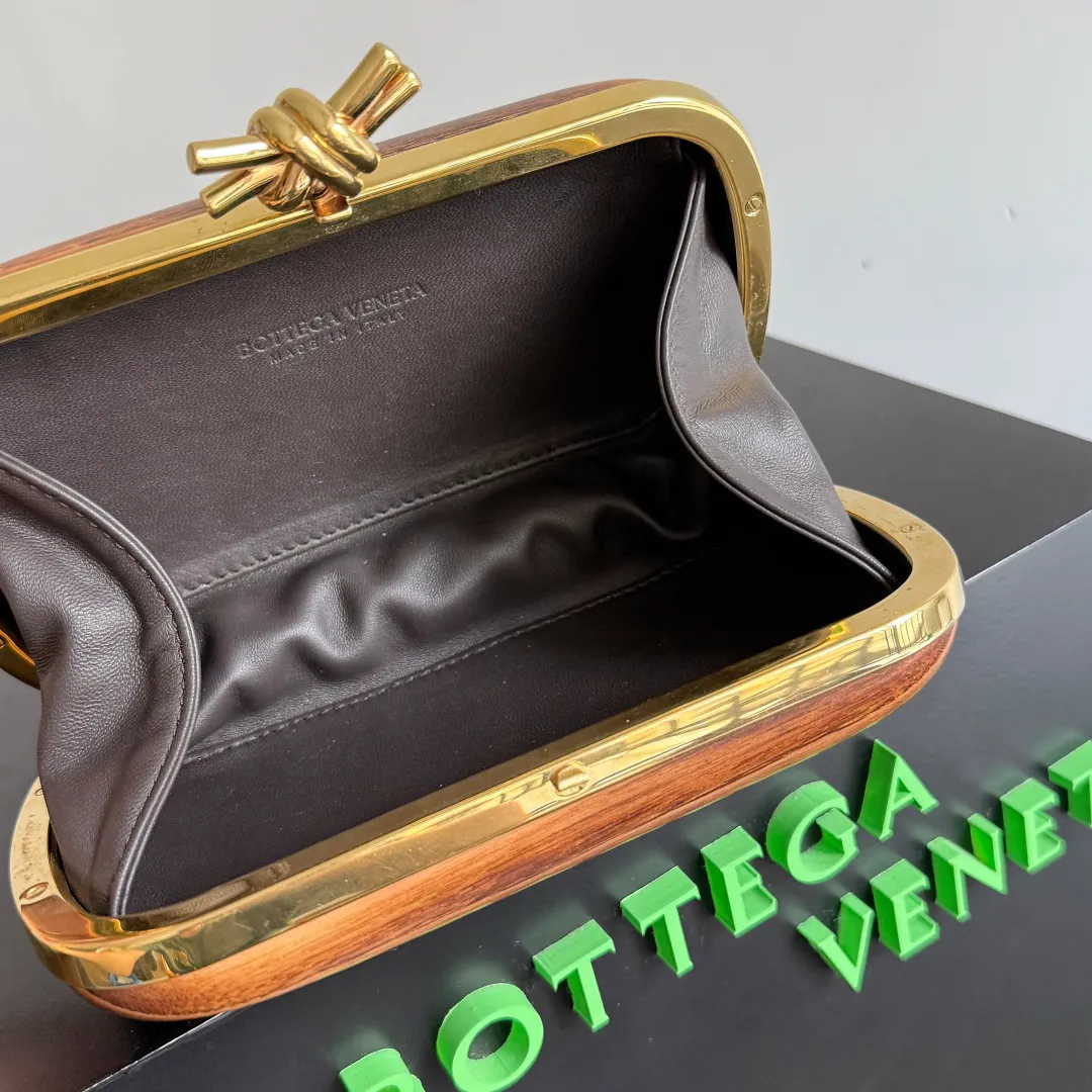 Batch 2720 BOTTEGA VENETA2025 new kont evening bag When the natural texture of wood meets the brass edge, the BV evening bag becomes a work of art in the fashion world. Every wood grain is a mark of time, delicate and unique. The brass metal buckle is embellished like stars, and opening it is full of ritual. It is the focus of the dinner party, and can easily store your exquisite small things. The warmth of wood and the cold and cool collision of metal tell the niche light luxury style in every gesture, allowing you to shine with a unique attitude in every feast. Style number: 804292 (717622) Color: maroon Size: 20.5*6*12.5cm
